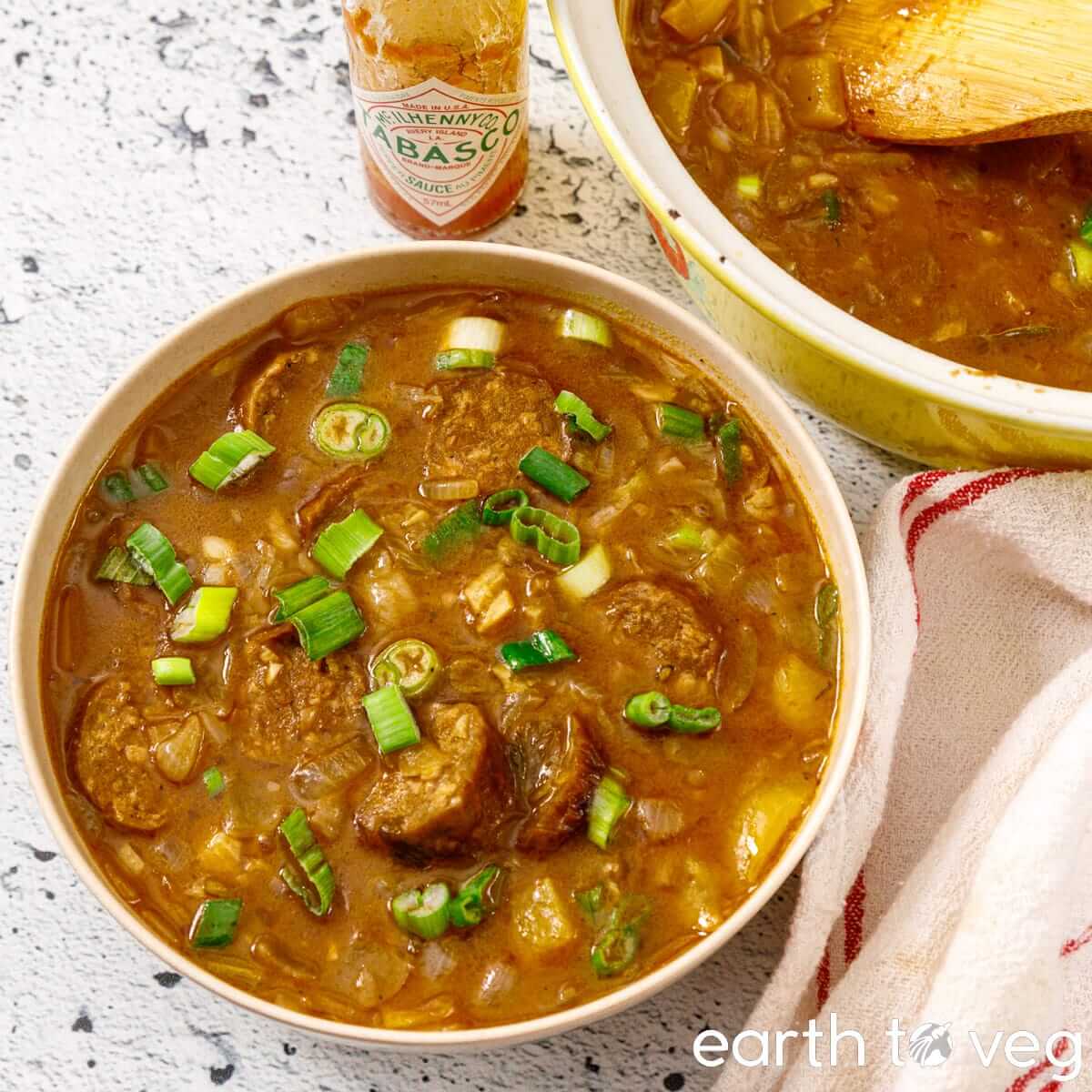 A bowl of plant-based gumbo with tabasco sauce on the side.